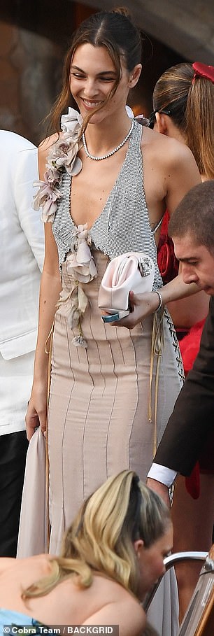 Vittoria's purple and silver frock plunged to flash her cleavage and was cinched in over her enviably svelte midriff, with the effect heightened by pinstripes