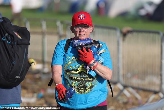 Litter pickers collect nitrous oxide canisters during the Glastonbury morning clean-up today