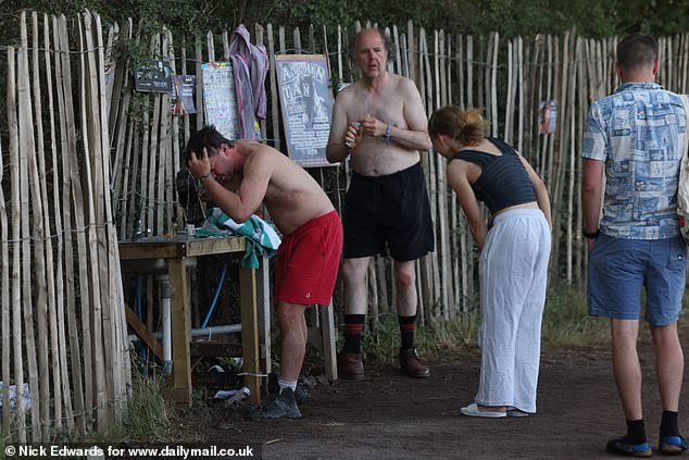 Glastonbury Festival revellers have a morning wash today at the site in Pilton, Somerset