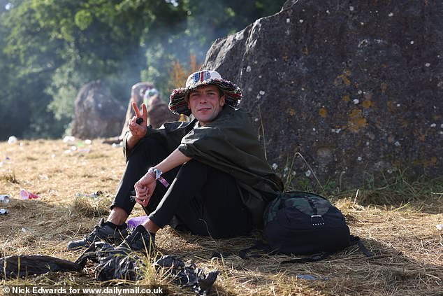 A Glastonbury festivalgoer poses for a photo at Worthy Farm in Somerset this morning