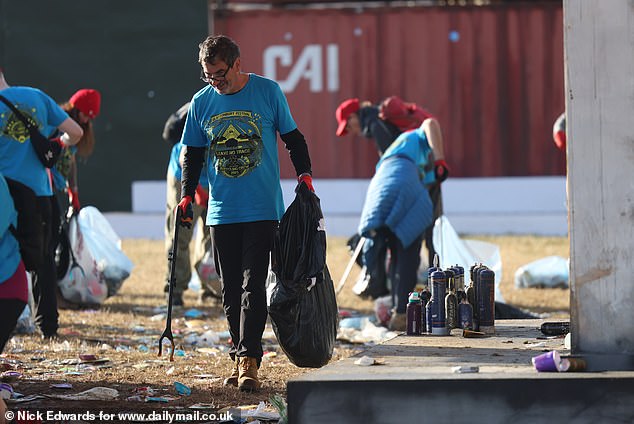 Litter pickers clear the Glastonbury site early this morning before the first bands play later