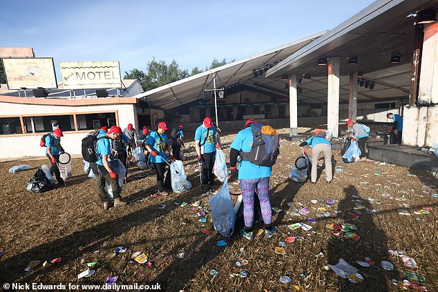 Litter pickers clear the Glastonbury site early this morning before the first bands play later