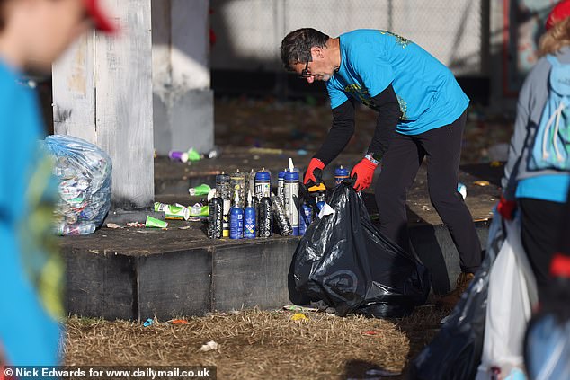 Litter pickers clear the Glastonbury site early this morning before the first bands play later