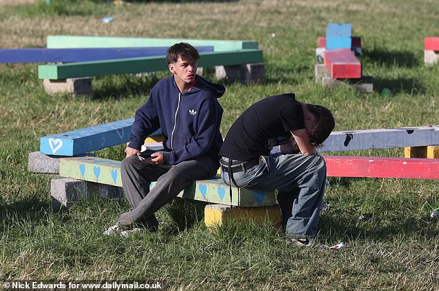 Glastonbury festivalgoers rest in the sunshine at Worthy Farm in Somerset this morning
