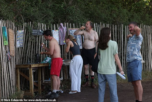 Glastonbury Festival revellers have a morning wash today at the site in Pilton, Somerset