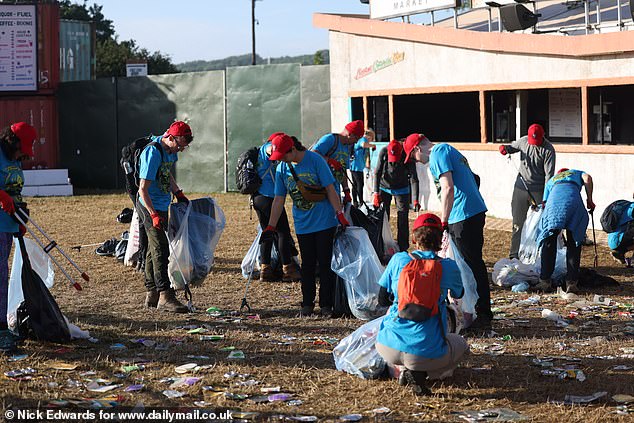 Litter pickers clear the Glastonbury site early this morning before the first bands play later