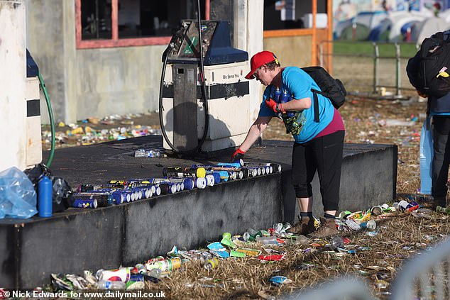 Litter pickers collect nitrous oxide canisters during the Glastonbury morning clean-up today