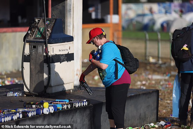 Litter pickers collect nitrous oxide canisters during the Glastonbury morning clean-up today