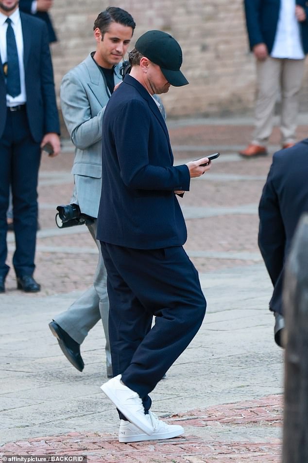The Oscar-winning actor, 50, was casually clad in a navy blazer and trousers while sporting his trademark baseball cap