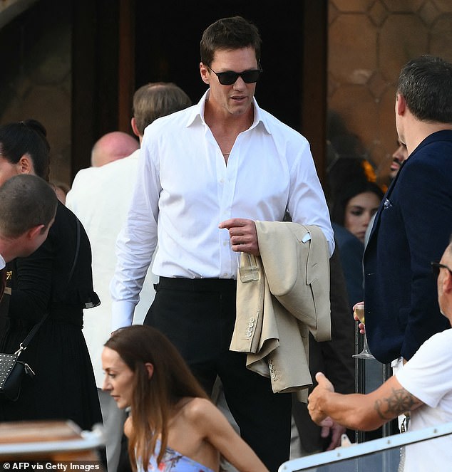He was guided towards a boat floating on the water while his blazer was draped over his left arm