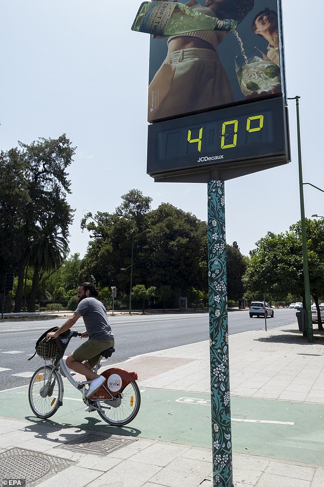 SPAIN: A cyclist rides next to a thermometer showing 40 degrees Celsius in Seville