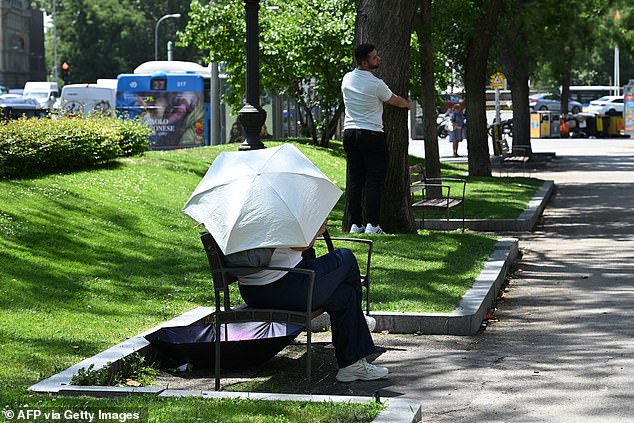 SPAIN: A person uses an umbrella as protection from the sun in Madrid