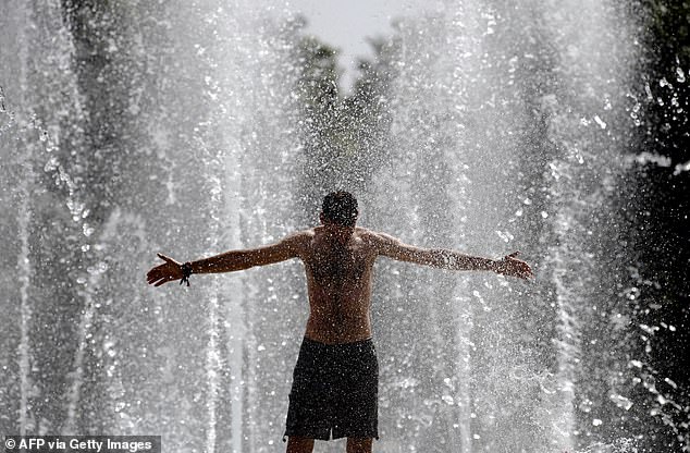 SPAIN: A man cools off in a fountain in Seville
