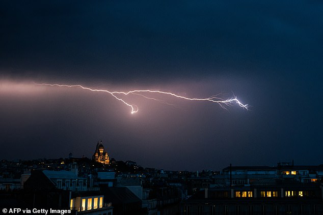 FRANCE: A lighting bolt lights up the sky over Sacre Coeur Basilica in Montmartre during a thunderstorm, northern Paris, on June 25