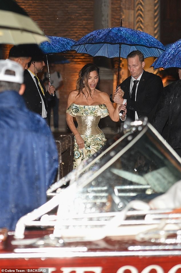 Bride-to-be Lauren was surrounded by tuxedo-clad gentleman carrying blue umbrellas over her