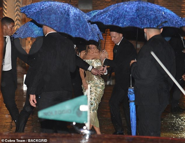 The scene was pure chaos as more than seven umbrella-wielding men ran to Lauren's side