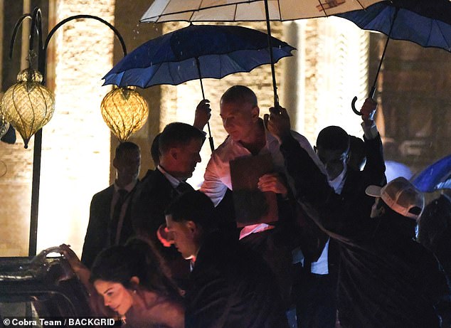 Bezos, 61, was seen following closely behind Lauren with an umbrella over his head