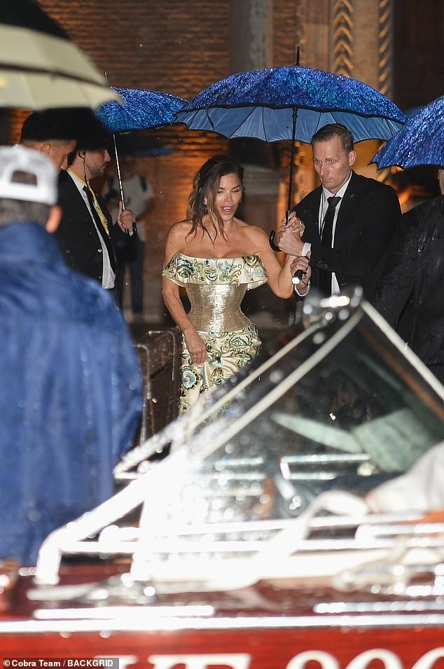 Bride-to-be Lauren was surrounded by tuxedo-clad gentleman carrying blue umbrellas over her