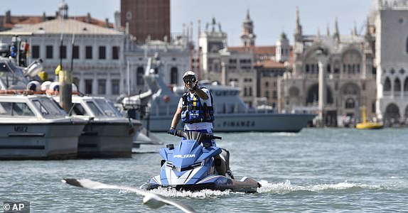 Police officers patrols the area in front of St.Mark's Square ahead of the anticipated wedding celebrations of Jeff Bezos and Lauren Sanchez, in Venice, Friday, June 27, 2025. (AP Photo/Luigi Costantini)
