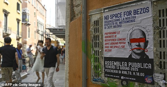 TOPSHOT - A poster reading "No Space for Bezos" and calling for protest, is pasted on a wall in Venice where the billionaire Jeff Bezos will marry is fiancee, journalist Lauren Sanchez at the end of the month, on June 13, 2025. Poster campaigns and stickers have spread throughout the city, including one with images of Bezos reading "No space for Bezos" as some local residents protest claiming the city is transformed into a playground for billionaires. (Photo by ANDREA PATTARO / AFP) (Photo by ANDREA PATTARO/AFP via Getty Images)