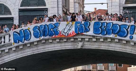 FILE PHOTO: Protesters display a banner reading "No Space for Bezos!" on the Rialto Bridge during a protest against Amazon founder Jeff Bezos' upcoming wedding to Lauren Sanchez being held in Venice, Italy, June 13, 2025. REUTERS/Manuel Silvestri/File Photo