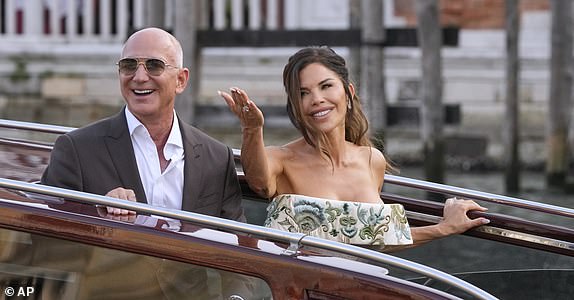 Jeff Bezos, left, and Lauren Sanchez kiss as they leave a hotel for their pre wedding reception, in Venice, Italy, Thursday, June 26, 2025. (AP Photo/Luca Bruno)