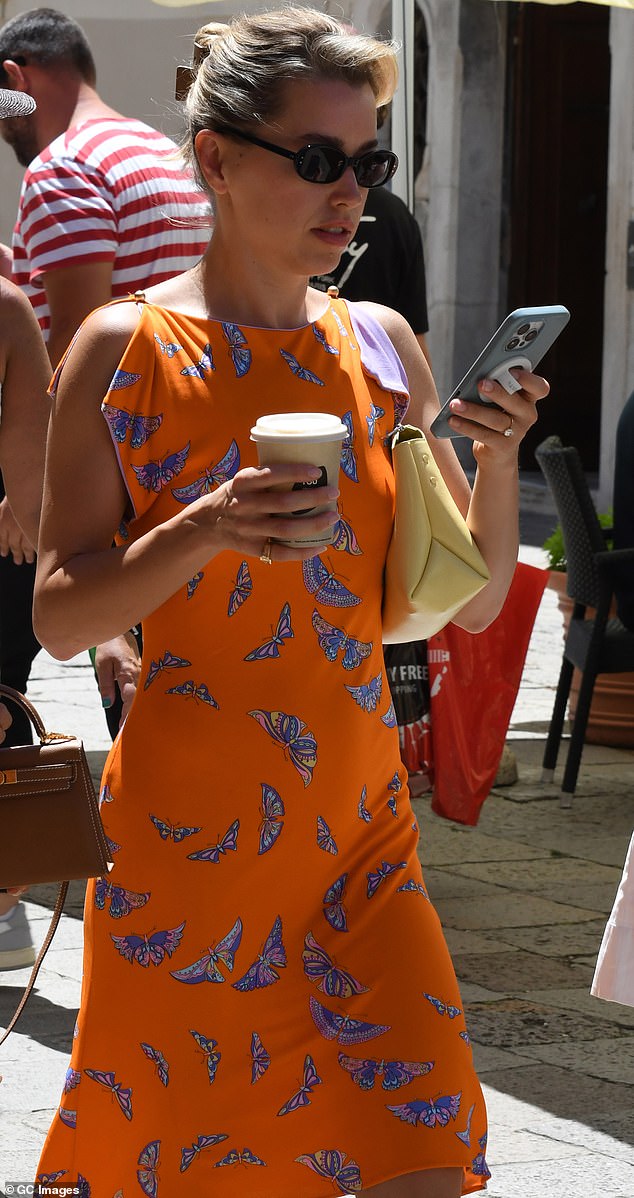 Butterfly fly away! Lydia Kives, who is married to Canadian investor Michael Kives, wore a sleeveless orange dress emblazoned with blue butterflies all over it