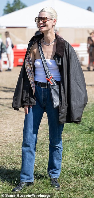 She paired the jacket with a white boob tube and belted straight-leg jeans