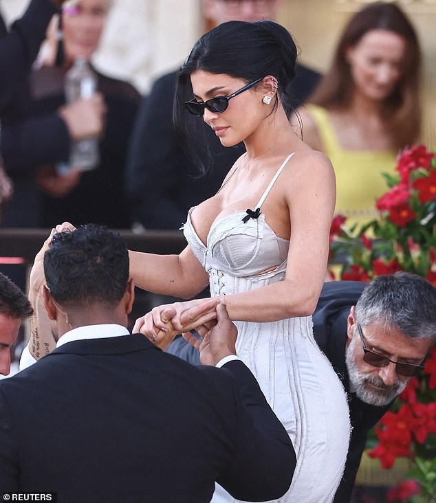 Jenner was photographed being helped onto a water taxi as she headed to the ceremony while wearing a white, corseted gown