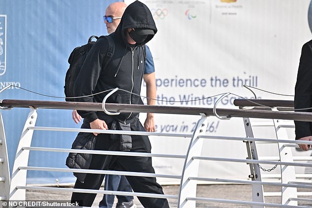 Dressed head-to-toe in an all-black ensemble – including a matching face mask, baseball hat and zip-up with the hood pulled over his head – Leo touched down in the Floating City on Thursday looking as if he were working undercover.
