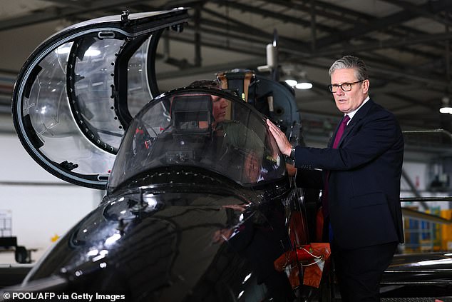 Britain's Prime Minister Keir Starmer (R) is shown a Hawk T2, the RAF's premier fast jet trainer during a visit to RAF Valley, on Anglesey in north-west wales on June 27, 2025
