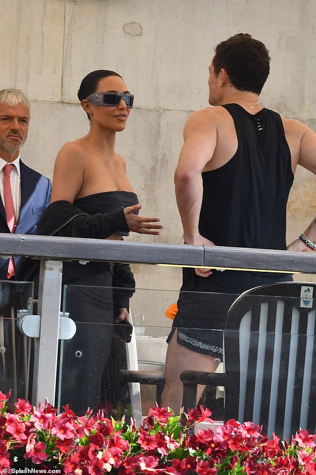 'Newly single' Orlando has been spotted chatting to Kim Kardashian as he attends Jeff Bezos's wedding alone