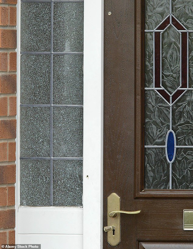 Bullet holes are seen in the door of Jennifer Ellison's front door with a glass window shattered after the AK-47 attack