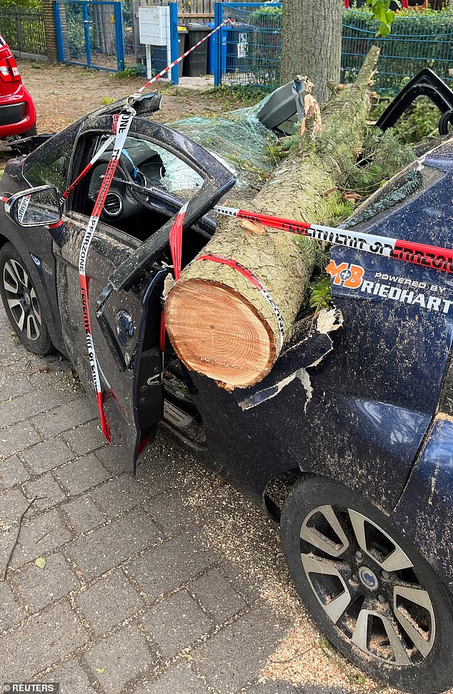 A damaged car sits on the street after a heavy storm swept across Germany and uprooted many trees, damaging buildings and vehicles