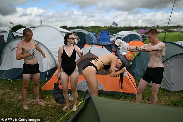 Festivalgoers wash among the tents on the fourth day of the Glastonbury festival