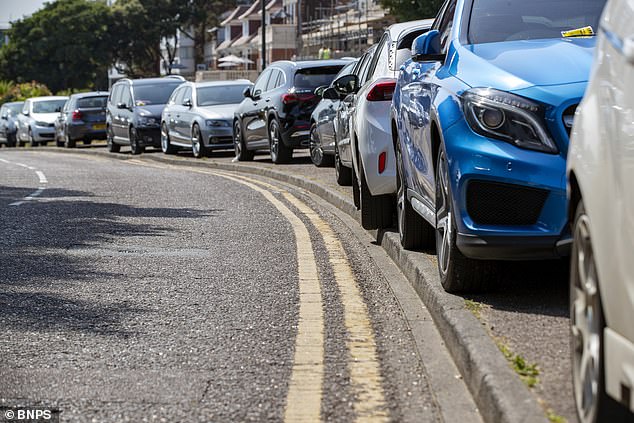 Drivers park illegally on the pavement on the East Cliff in Bournemouth as people flock to the beach