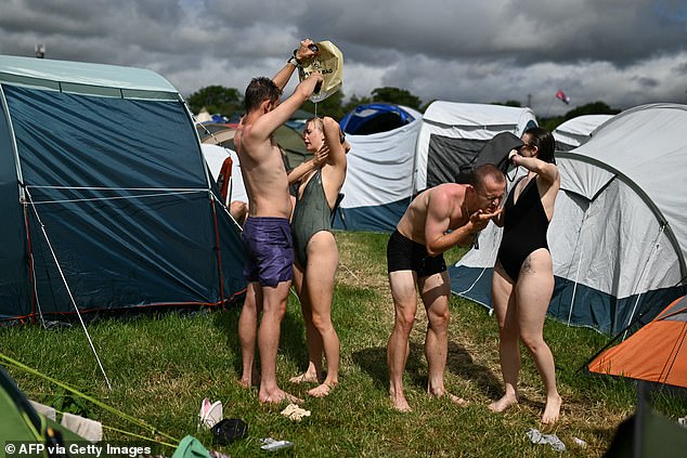 Festivalgoers wash among the tents after three days of the Glastonbury festival