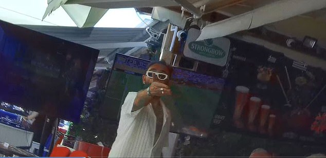 A worker at Lindos Bar signalling to the reporter to take a seat while serving another customer. The bar brought out a fishbowl and insisted it was the smallest cocktail option
