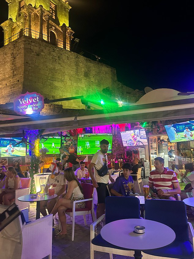 When the reporter walked past the venue in the late evening, it was filled with people drinking from large 'boots' and fishbowls. The parasols were taken down and the sign could be seen