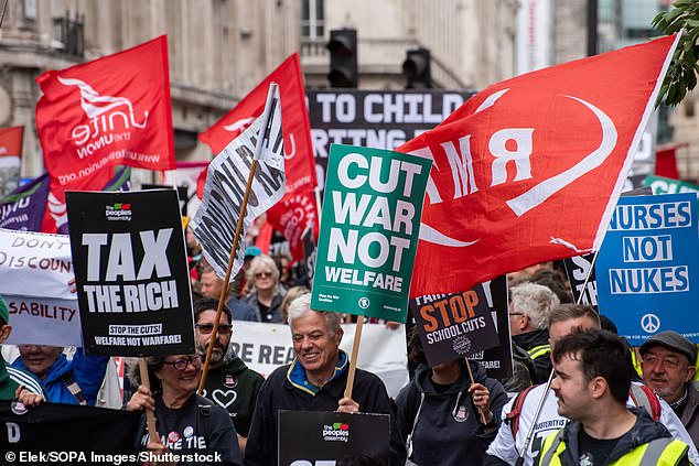 Protesters march with flags and placards during the Welfare Not Warfare' demonstration