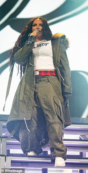 She completed the look with chunky white trainers and layered a khaki parka over her shoulders, which featured a sparkling diamante embellishment