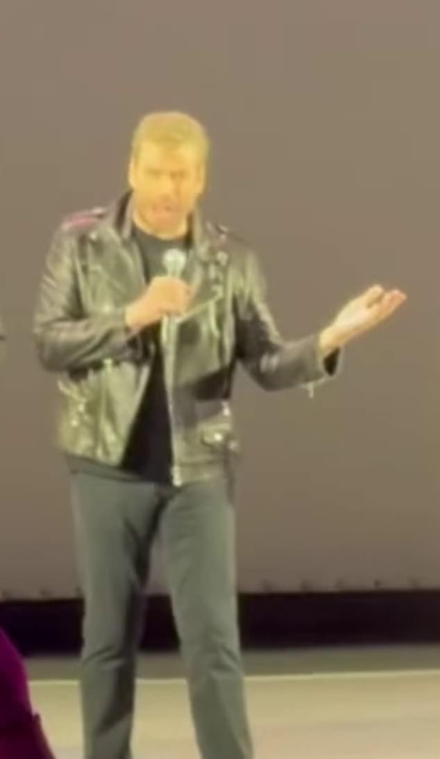 Travolta swaggered on to stage wearing a pair of dark jeans, a tight black T-shirt and a black leather jacket