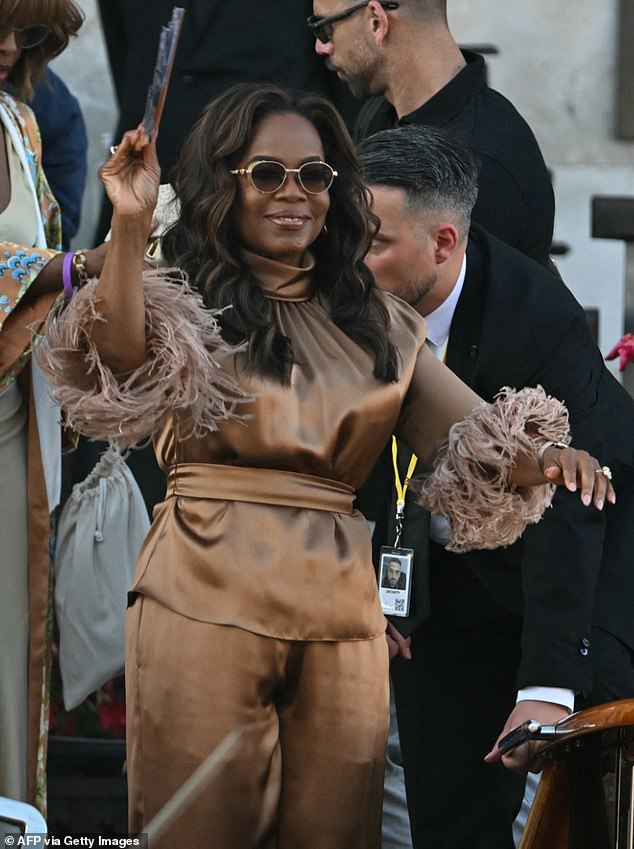 Oprah Winfrey, 71, showed up in a chic, silk brown co-ord that boasted fringe sleeves. She wore her hair down in lose curls and hid behind a pair of shades as she waved to adoring fans