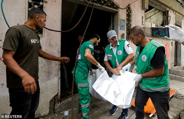 People carry the body of a Palestinian at the site where a journalist and three Palestinian medics were killed in an Israeli strike