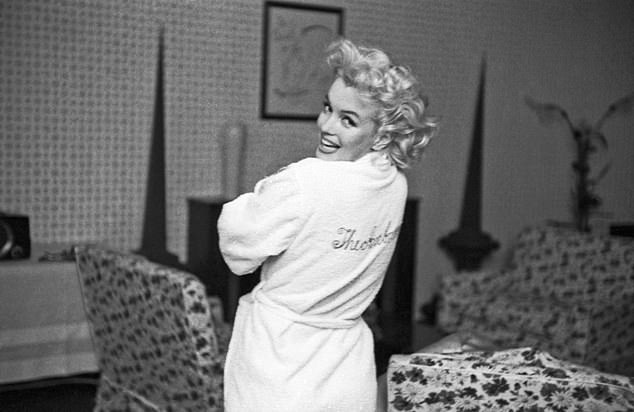 Marilyn wears an embroidered robe reading 'The Ambassador' at the Ambassador Hotel in New York City