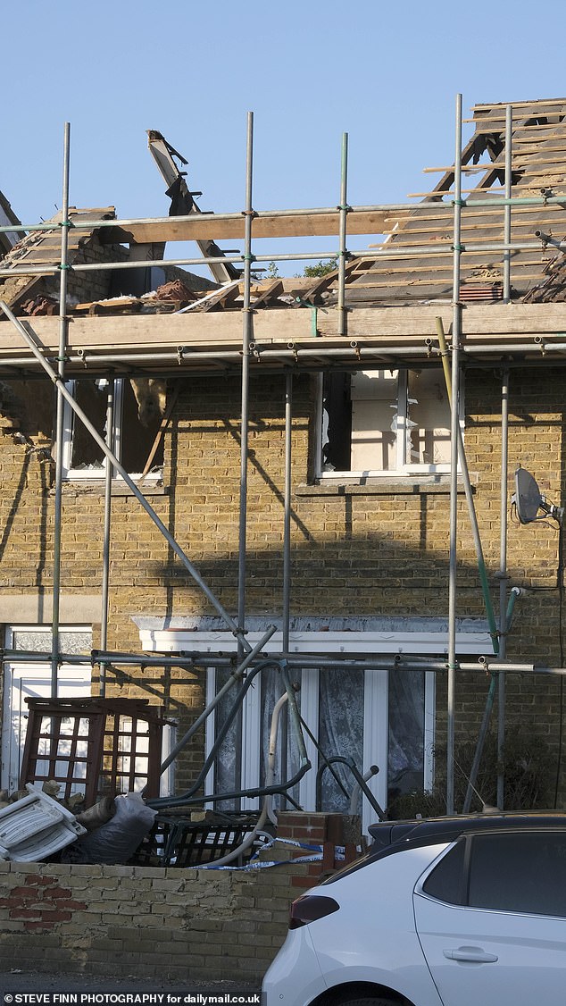 Louis Scudder, 52, snapped last summer when he climbed onto the roof of his £150,000 home and embarked on a one-man wrecking mission (Pictured: the damage to the property)