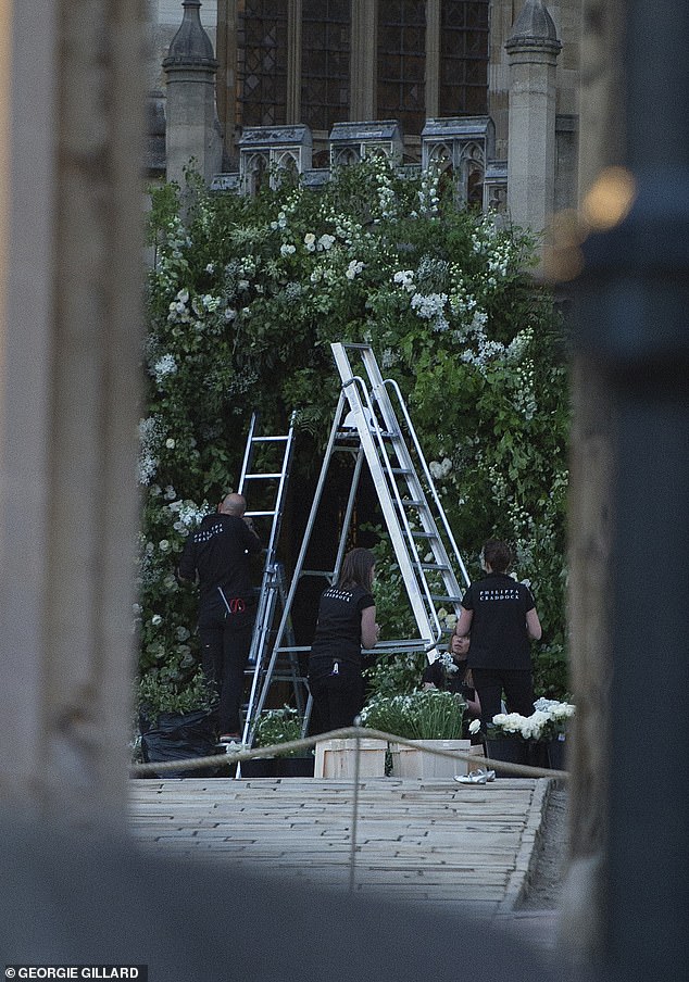 A team of florists are pictured installing the floral archway for the Sussexes' wedding
