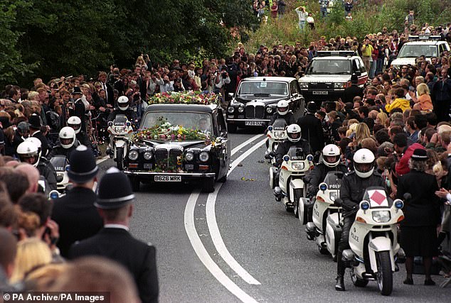 Crowds gather by the road as the hearse carrying the coffin of Diana arrives at the gates of Althorp House