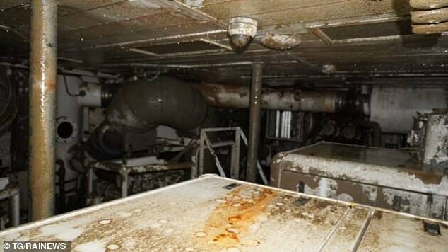 The engine room is cased in dirt as haunting photos show the mud-caked interior of the vessel following its near year-long stay 160ft under the sea