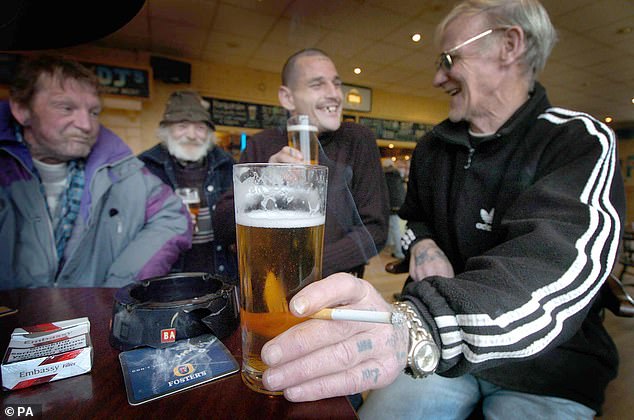 A man holds a cigarette at the Limerick pub in Tipton, West Midlands, in November 2004